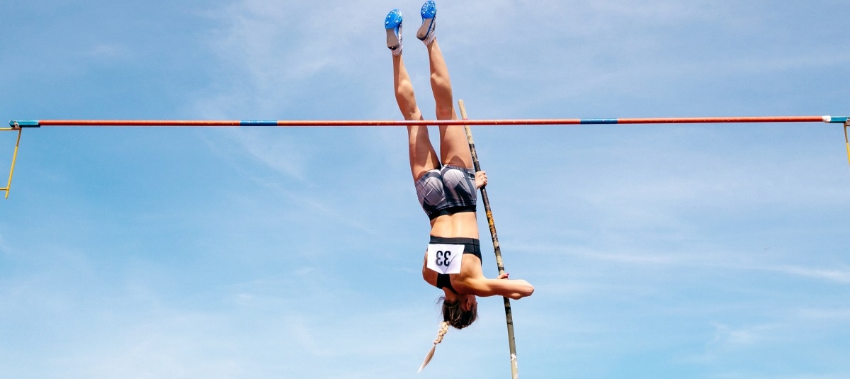 Zawodniczka w dyscyplinie sportowej skok o tyczce na tle nieba